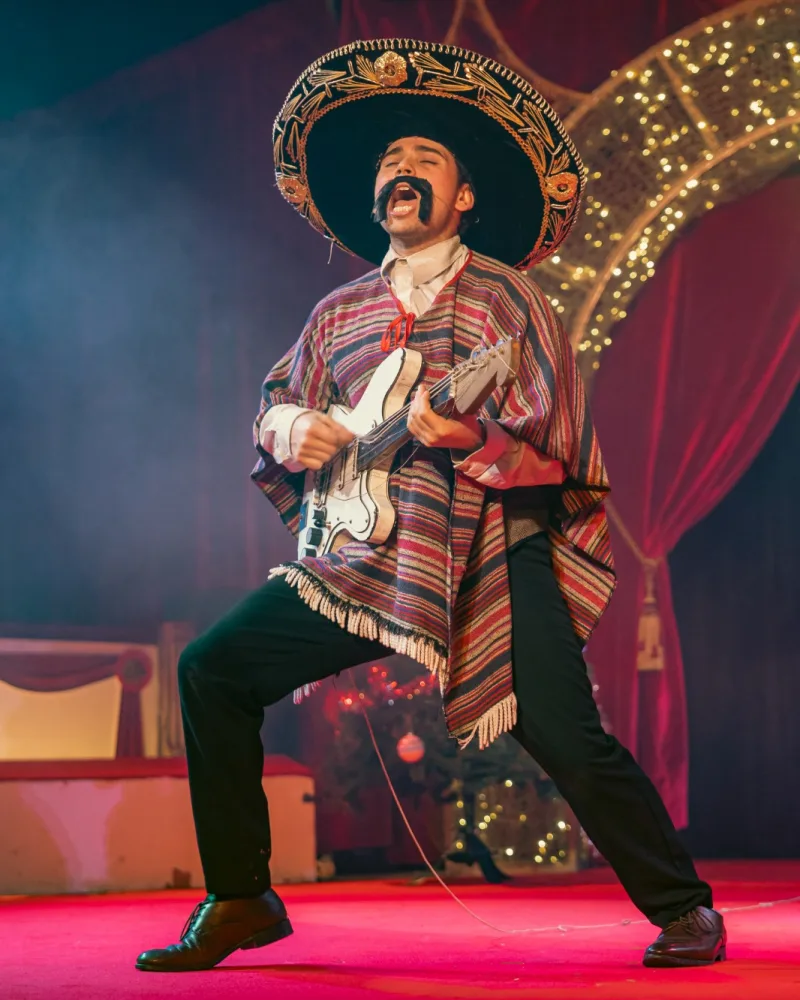 Grego del Moustico de la Gripaviera met sombrero, poncho en gitaar op het podium