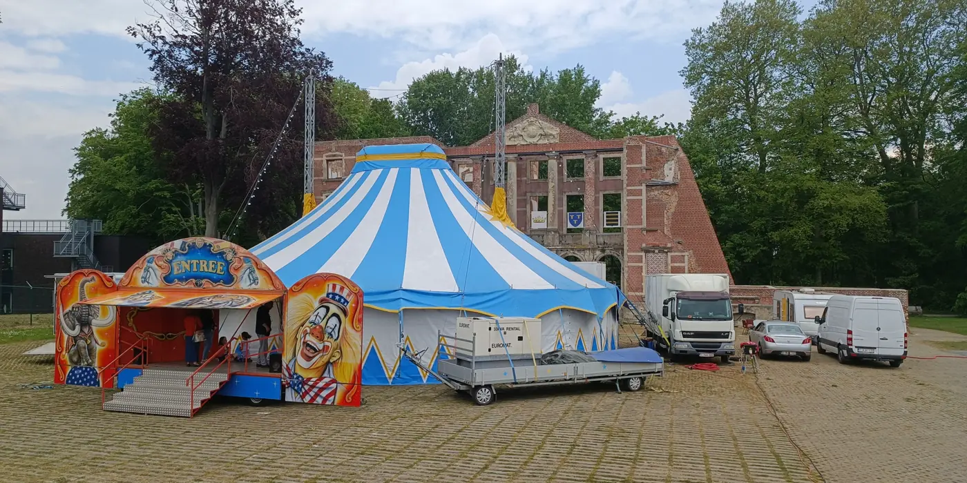 Blauw-witte circustent van Patatje & Charlie op een dorpsplein